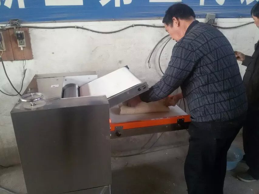 工作人員在揉壓機(jī)中進(jìn)行揉壓