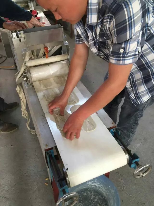 工作人員和王先生在車(chē)間進(jìn)行機(jī)器調(diào)試